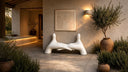 White abstract fiberglass sculpture with a smooth glossy finish in a warm interior setting.