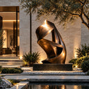Abstract bronze ribbon sculpture BB-014 displayed beside a reflecting pool in a modern landscaped courtyard