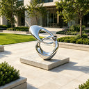 Abstract stainless steel loop sculpture with fluid geometric form and polished reflective surface for contemporary architectural spaces