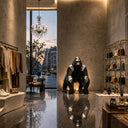 Black stainless steel gorilla sculpture displayed in a modern luxury interior as a contemporary art centerpiece