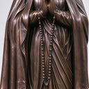 Close-up of the clasped praying hands, hanging rosary beads, and detailed bronze robes of the Blessed Mother statue BB-054.