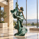 A bronze dancer statue raises one arm above a sweeping verdigris dress, creating a graceful focal point for a hotel lobby.
