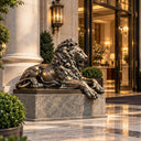 Serving as a bronze guardian lion statue, this outdoor entrance sculpture takes a reclining posture on a dark plinth for luxury estate entrances.
