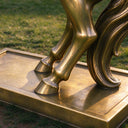 Articulating the structural connection, this detail shot traces the bronze hooves resting upon the rectangular mounting plinth of the artwork.