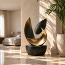 A bronze leaf sculpture balances dark tapered forms with a sweeping gold curve and textured surfaces, creating a focal point for a villa interior.