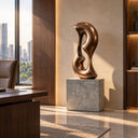 Characterized by fluid organic curves, this brown patina bronze sculpture rests on a stone pedestal, destined for upscale luxury interiors.