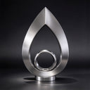 Isolated against a dark studio backdrop, this brushed stainless steel sculpture displays the crisp teardrop silhouette and inner ring detail, photographed for design catalogs.