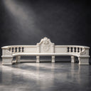 Under a dark studio spotlight, this classical marble bench reveals hand-finished ornament and a sweeping curved profile, archived for custom marble estate seating catalogs.