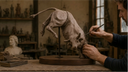 Sculptor hand modeling a detailed clay bull for a custom bronze sculpture