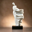 Close-up of a white flowing figure art sculpture with a dark base under warm lighting, showcasing its elegant lines and premium texture, ideal for high-end art decor reference.