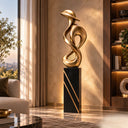 Displaying a continuous looped design with a polished finish, this contemporary infinity bronze sculpture is set upon a striped black pedestal for a luxury living room.