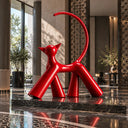 Contemporary red animal sculpture with a high-gloss finish serving as a statement artwork in an upscale modern hotel lobby.