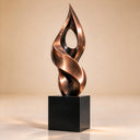 Imaged within a neutral studio setting, this custom architectural bronze sculpture features a hollow, twisted flame silhouette on a geometric pedestal, prepared for art collection catalogs.