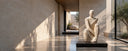 Custom natural stone figurative sculpture displayed in a contemporary art museum with a minimalist architectural interior.