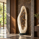 Framed by an open Egyptian Beige marble oval, bronze flower forms rise above a dark stone base within a contemporary entrance hall.