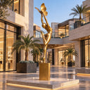 Balancing elegantly on a square pedestal, this female bronze garden sculpture imparts a dynamic vertical silhouette to a sunlit resort terrace.