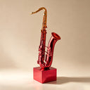 Close-up detail of painted stainless steel saxophone sculpture showing glossy red finish and handcrafted metal curves