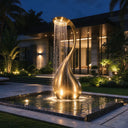 Gold stainless steel sculptural fountain with cascading water in a luxury villa garden at night