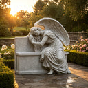 Gray granite weeping angel memorial MM-022 with a carved wing and integrated monument in a landscaped garden