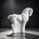 Imaged against a dark studio backdrop, this minimalist marble horse statue reveals the hand-carved texture and abstract form, created for contemporary art gallery collections.