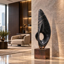 Carved from black marble, this Eternal Ascent sculpture encapsulates an abstract flame form with a circular opening, destined for luxury homes and executive spaces.
