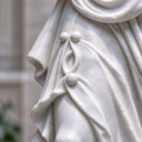 Exposing the intricate folds of the gown, this hand-carved marble garden statue details the meticulous craftsmanship applied to the classical female figure.