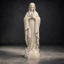 Photographed on a dark studio backdrop, this hand-carved religious statue accentuates the flowing robes and serene expression of the Marble Madonna for product catalogs.