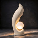 Sculpted in Egyptian Beige marble, this illuminated outdoor sculpture centers on a glowing orb, presented against a dark studio background for design catalogs.