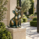 Large bronze cat statue BB-018 looking up at a butterfly in a landscaped formal garden