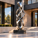 Springing from a solid black base, this large outdoor infinity sculpture is mirror polished from stainless steel, defining an abstract metal ribbon design for corporate landscape projects.