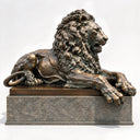 Captured in a studio setting, this large bronze lion sculpture with a granite pedestal highlights intricate mane textures, prepared for design catalog references.