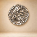 Documented against a warm studio background, this large stainless steel wave sculpture features polished metal ridges and grooves, highlighting its sculptural depth for design catalogs.