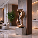 This lost-wax cast bronze artwork displays a twisting, interconnected profile, placed in an executive office setting with wooden shelving and warm lighting in the background. 