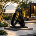 Black stainless steel abstract sculpture SS-023 displayed in a luxury garden landscape with modern architectural surroundings