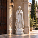 Reverently shaped with clasped hands, this marble Virgin Mary statue stands as a Catholic outdoor religious figure, designed for a serene parish garden.