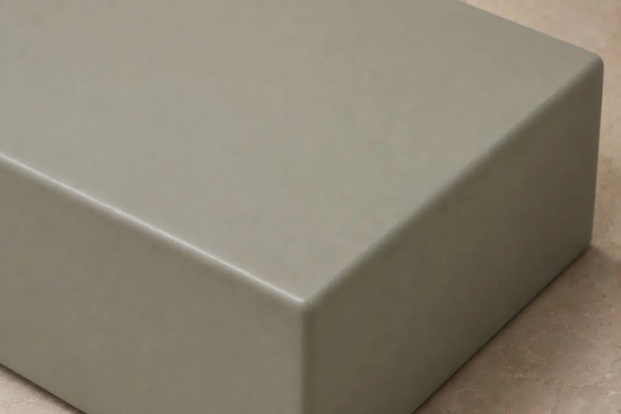 Matte sage green finish sample displayed on a light beige stone surface