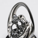 Close-up of intricate intertwined stainless steel forms revealing layered curves, open spaces, and reflective mirror-polished surfaces.