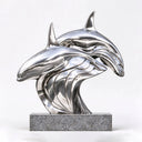 Close-up of the mirror-polished stainless steel dolphin sculpture showing smooth reflective surfaces and flowing metal contours
