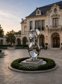 Mirror-polished stainless steel female figure sculpture in a luxury residential courtyard