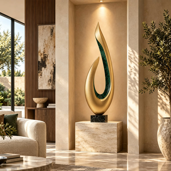 Modern abstract gold teardrop sculpture with a green inlay accent on a black base, placed in a luxury living room with beige sofas and marble surfaces, ideal for high-end interior art decoration.