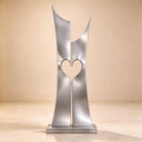 Isolated on a neutral studio backdrop, this modern metal heart artwork showcases the flawless reflective surface and minimalist geometry of contemporary steel art.
