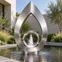 Contemporary stainless steel ring fountain with a brushed silver finish in a modern villa courtyard reflecting pool