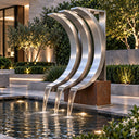 Modern stainless steel triple arc fountain SS-031 flowing into a reflecting pool in a landscaped luxury garden