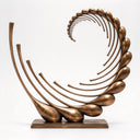 Photographed against a light studio backdrop, this monumental abstract bronze sculpture highlights the fluid curves and solid teardrop accents of the Infinite Tide design.