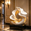 Organic abstract stainless steel sculpture with flowing curved form and polished surface creating a contemporary artistic centerpiece