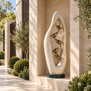 An oval marble sculpture encloses ascending cast bronze flower forms, pairing Egyptian Beige stone with a warm brown patina for a villa courtyard.