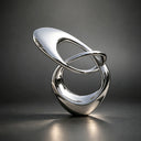 Close-up detail of polished stainless steel loop sculpture showing reflective surface, smooth curves, and precision craftsmanship