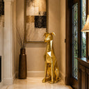 Stainless steel gold dog sculpture displayed in a luxury villa