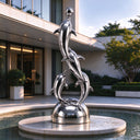 Mounted on a circular domed plinth, this stainless steel dolphin sculpture elevates the modern architecture of a luxury resort entrance.