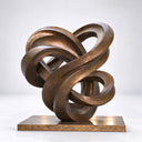 Studio shot of an abstract bronze loop sculpture on a light background, highlighting its polished metallic texture and flowing intertwined design for art decor product display and reference.